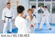 Teens in kimonos honing punches during kumite at karate training. Стоковое фото, фотограф Яков Филимонов / Фотобанк Лори