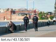 Moscow, Russia - May 15, 2023: Translation of the text in Russian - МВД  - MVD of Russia - Ministry of Internal Affairs of Russiaю Street photography. Police men on the duty in the city park. Backs. Редакционное фото, фотограф YuryKara / Фотобанк Лори