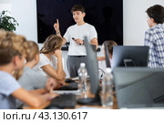 Young male teacher speaking to underage attendees of computer courses. Стоковое фото, фотограф Яков Филимонов / Фотобанк Лори