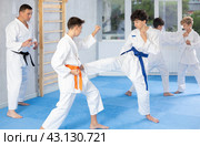Twen boys in kimonos honing karate kicking techniques during kumite. Стоковое фото, фотограф Яков Филимонов / Фотобанк Лори