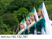 Adygea, RUSSIA - JULY 25 2015: Young Circassian girls in beautiful national costumes on the background of a green forest in close-up. Редакционное фото, фотограф Андрей С / Фотобанк Лори