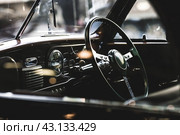 Classic luxury interior of a retro car and a close-up steering wheel. Russia, May 11, 2024. Редакционное фото, фотограф Photojuli / Фотобанк Лори