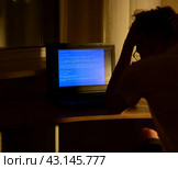 Man holds his head looking at the blue screen of the monitor, the crash of the operating system. repair and installation concept licensed software. Стоковое фото, фотограф Дмитрий Львович Алферов / Фотобанк Лори