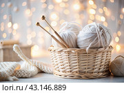 Balls of yarn in a wicker basket in white and beige tones. Needlework, textiles, knitting. Winter season, small business, handmade clothes. Стоковое AI-изображение, AI-художник Photojuli / Фотобанк Лори