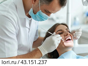 The dentist performs a preventive examination of the patient's teeth. The concept of dentistry. Стоковое AI-изображение, AI-художник Ярославский Максим / Фотобанк Лори
