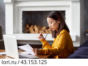 Asian woman working at home looking at documents. Beautiful Japanese female. Стоковое фото, фотограф Natalia Gdovskaia / Фотобанк Лори