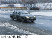 ZAZ Sens car moving on the winter city street during snowfall. Редакционное фото, фотограф Константин Григорьев / Фотобанк Лори