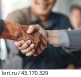 Close-up of hands in a firm handshake after a triumphant partnership in the office, A powerful image capturing the essence of mutual achievement and collaboration. Стоковое AI-изображение, AI-художник Ярославский Максим / Фотобанк Лори