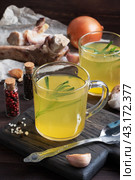 Homemade beef bone and vegetable broth with turmeric seasoning in a glass. Healthy food with collagen and amino acids. Copy space. Стоковое фото, фотограф Глущенко Елена / Фотобанк Лори