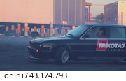 A black retro car takes a turn in a drift with smoke from under the wheels at the Mega Belaya Dacha site. The drift festival. Russia. Moscow. 19.05.2024. Редакционное видео, видеограф Ярославский Максим / Фотобанк Лори