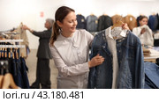 Adult woman choosing denim jacket in store. Стоковое видео, видеограф Яков Филимонов / Фотобанк Лори