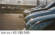 Cars in a row in the parking lot in the sunset against the background of freeway traffic (2024 год). Редакционное видео, видеограф Ярославский Максим / Фотобанк Лори