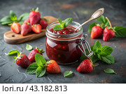 A jar of homemade strawberry, healthy jam with mint on a black background. Conservation and harvesting in summer. Стоковое AI-изображение, AI-художник Photojuli / Фотобанк Лори