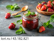 A jar of homemade strawberry, healthy jam with mint on a black background. Conservation and harvesting in summer. Стоковое AI-изображение, AI-художник Photojuli / Фотобанк Лори