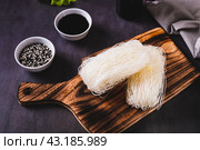 Two servings of funchose dry rice noodles on a board on the table. Стоковое фото, фотограф Елена Руй / Фотобанк Лори