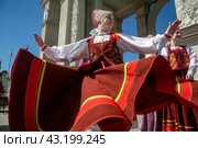 Девушки в русских национальных костюмах водят хороводы и поют народные песни у арки Центрального входа на территорию выставочного комплекса ВДНХ в городе Москве, Россия (2024 год). Редакционное фото, фотограф Николай Винокуров / Фотобанк Лори