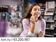 Young girl testing face concealer in beauty store. Стоковое фото, фотограф Яков Филимонов / Фотобанк Лори