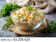 Traditional Russian Olivier salad for a feast on a plate on a wooden countertop. generative AI. Стоковое AI-изображение, AI-художник Photojuli / Фотобанк Лори
