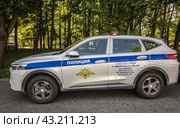 Полицейский автомобиль стоит на дороге. Надпись "Полиция" крупным планом (2024)/  A police car is standing on the road. The inscription "Police" close-up. Редакционное фото, фотограф Iva Noel / Фотобанк Лори