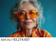 Happy cool old lady portrait, grandmother with extravagant style, fashionable clothes, seniority and elderly people, blue background. Стоковое AI-изображение, AI-художник Станислав Тарко / Фотобанк Лори