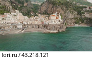 Aerial view of Atrani coastline with its iconic church and beach area, showing the turquoise sea waters (2024 год). Стоковое видео, видеограф Igor Tichonow / Фотобанк Лори