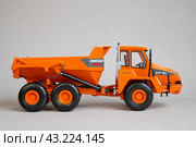 Грузовой самосвал Doosan южнокорейского производства — игрушечная миниатюрная модель на сером фоне (2023 год). Редакционное фото, фотограф Дорощенко Элла / Фотобанк Лори