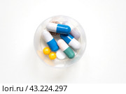 Таблетки, капсулы и гранулы в контейнере на светлом фоне. Суточная доза лекарств. Витамины для лечения и профилактики. Стоковое фото, фотограф Дорощенко Элла / Фотобанк Лори
