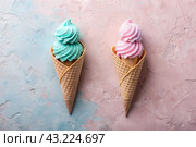 The banner. Sweet dessert. Ice cream cones with different flavors. Blue, pink ice cream on a background of two pastel colors: blue and pink. Стоковое AI-изображение, AI-художник Photojuli / Фотобанк Лори