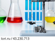 Laboratory scales with weights against test tubes. Стоковое фото, фотограф Сергей Толмачёв / Фотобанк Лори