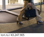 Somebody leaving the building in Moscow city. Woman leaving  modern office building in night. She is going home after long business day. Occupation theme. Low angle view. Стоковое фото, фотограф YuryKara / Фотобанк Лори