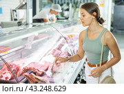 Young woman purchaser buying meat in butcher shop. Стоковое фото, фотограф Яков Филимонов / Фотобанк Лори