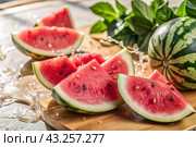 Close-up of fresh watermelon berries. Delicious berries and fruits of bright red color with drops of water. Vegetarianism. Healthy eating. Fresh fruits on the table. Стоковое AI-изображение, AI-художник Photojuli / Фотобанк Лори