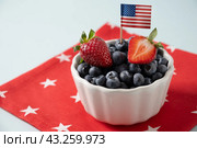 Blueberry decorated American flags for Independence Day on blue background. Стоковое фото, фотограф Светлана Лажко / Фотобанк Лори