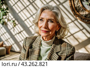 Minimalism. A studio portrait of a stylish, elegant elderly woman, a pensioner of 70 years old, in an interior and clothes of calm tones. The concept of the elderly. Стоковое AI-изображение, AI-художник Photojuli / Фотобанк Лори
