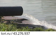 Water from the pipe falls into the lake, creating splashes. Стоковое видео, видеограф Юрий Поздников / Фотобанк Лори