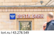 Moscow May 05 2024. Pochta Bank. Sign on building, passers-by walking by blurred in foreground. Редакционное фото, фотограф Скрипачев Антон / Фотобанк Лори