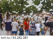 Kamennomostsky, Russia - September 1, 2018: Happy children having fun at a foam party at a holiday town day in an autumn park. Редакционное фото, фотограф Андрей С / Фотобанк Лори