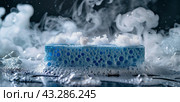 Blue Cleaning Sponge Surrounded By Soap Bubbles and White Smoke. Стоковое AI-изображение, AI-художник Юлия Гапеенко / Фотобанк Лори