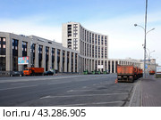 Здание Внешэкономбанка и камазы на проспекте Академика Сахарова в центре Москвы. Солнечный день (2022 год). Редакционное фото, фотограф Александр Кузнецов / Фотобанк Лори
