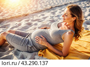 Relaxation, peace of mind, sea air. Close-up of the tummy. A pregnant woman on the beach by the sea. The concept of pregnancy, childbirth and parental responsibilities. Стоковое AI-изображение, AI-художник Photojuli / Фотобанк Лори