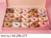 Delicious dessert. A sick box of different donuts with colorful sprinkles on the table. Confectionery products. Стоковое AI-изображение, AI-художник Photojuli / Фотобанк Лори