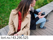 Молодая пара гуляет в лесопарке и пользуются смартфоном. Смартфон в руках. Стоковое фото, фотограф Терехова Марина / Фотобанк Лори
