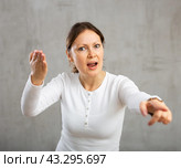 Indignant adult woman girl gesturing in studio. Стоковое фото, фотограф Яков Филимонов / Фотобанк Лори