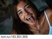 A woman is pulling a silly expression, with her mouth wide open. Стоковое AI-изображение, AI-художник Данила Большаков / Фотобанк Лори