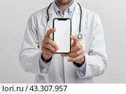 Врач показывает смартфон крупным планом. Смартфон с белым пустым экраном. Generative AI. Стоковое AI-изображение, AI-художник Щеголева Ольга / Фотобанк Лори