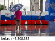 Инсталляция в цветах российского триколора в виде слова БРИКС установлена на площади перед аркой Центрального входа на выставочный комплекс  ВДНХ в городе Москве, Россия (2024 год). Редакционное фото, фотограф Николай Винокуров / Фотобанк Лори