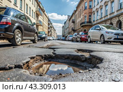 The terrible condition of the roads. A hole in the asphalt on a city street. Road repairs. A city street of poor quality. Стоковое AI-изображение, AI-художник Photojuli / Фотобанк Лори