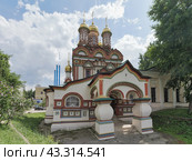 Главный вход в единоверческий Храм Николая Чудотворца на Берсеневке. Москва, район Якиманка. Памятник архитектуры. Голубое небо, белые облака. Трубы ГЭС-2. (2024 год). Редакционное фото, фотограф Сергей Никифоров-Гордеев / Фотобанк Лори