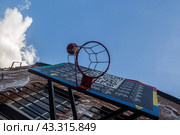 Баскетбольный мяч летит в кольцо во время игры в баскетбол на уличной площадке в городе Москве, Россия (2024 год). Редакционное фото, фотограф Николай Винокуров / Фотобанк Лори
