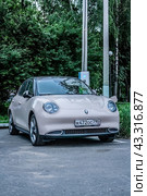 An electric car, GWM ORA 03, is parked on the street and is charging (2024 год). Редакционное фото, фотограф Константин Григорьев / Фотобанк Лори